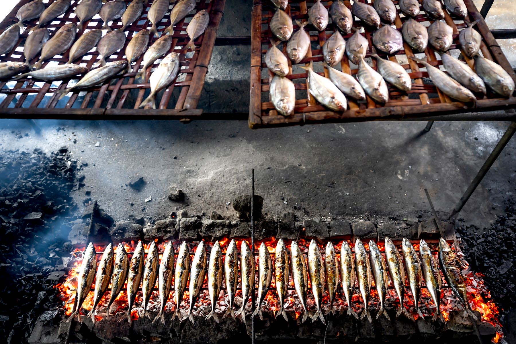 Peixe a assar numa grelha a carvão